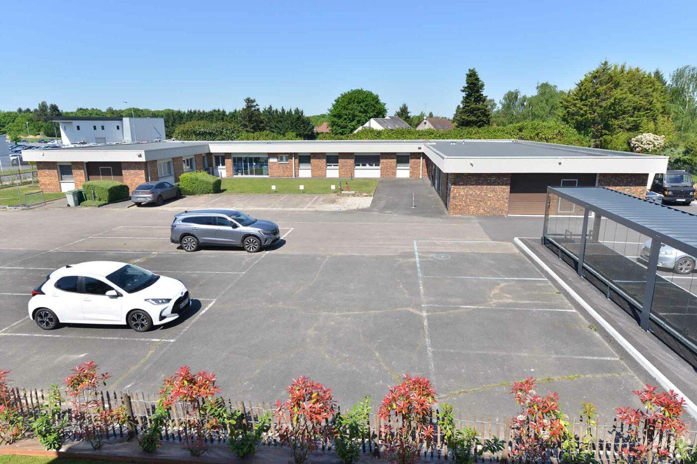 Extérieur du bâtiment QUALICONSULT SCHNEIDER avec parking